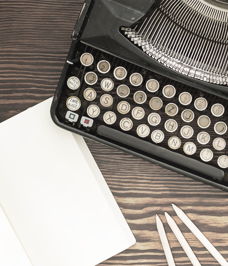 Image showing vintage typewriter with a blank sheet of book and pencils on a wooden surface.