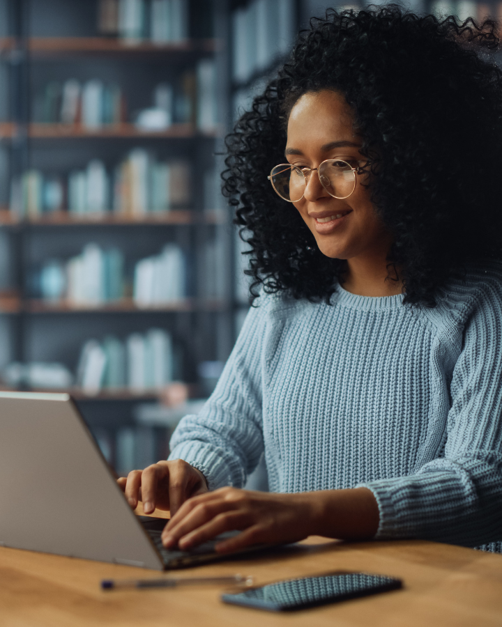 A woman typing on the a laptop