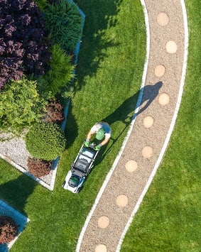 Aerial view of a compound with a guy mowing the lawn
