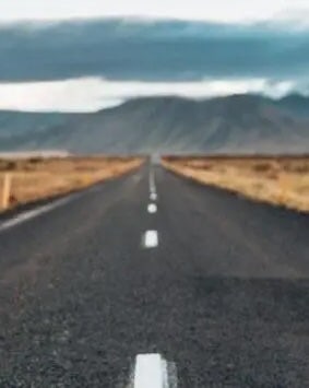 Straight road leading towards the horizon with a desert landscape