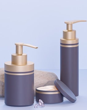 Elegant bathroom accessory set on a soft blue background.