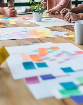 Team brainstorming with colorful sticky notes on a table.