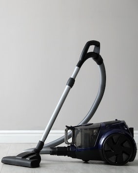 Vacuum cleaner on a grey background, depicting cleanliness